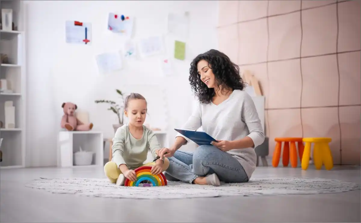 Experta en psicología en sesión terapéutica con una niña usando juguetes en un consultorio amplio y colorido